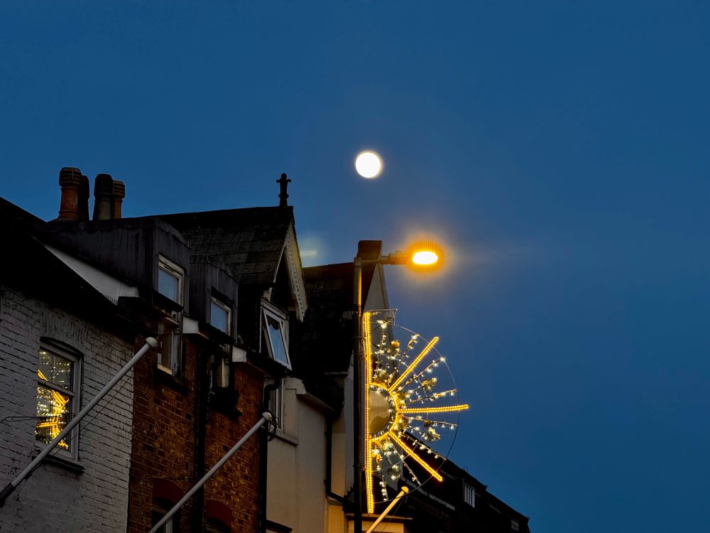 The moon in the dark blue evening sky. Waxing Gibbous, will be full tomorrow.