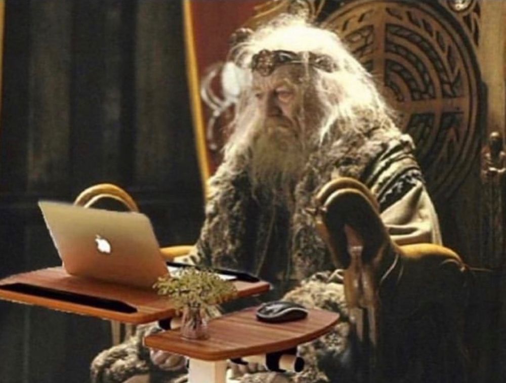 Possessed Théoden from Lord of the rings sitting at his desk and looking dauntingly at the screen of his MacBook.