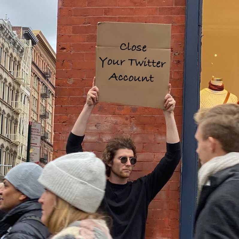 A man holding a sign saying “Close your twitter account”