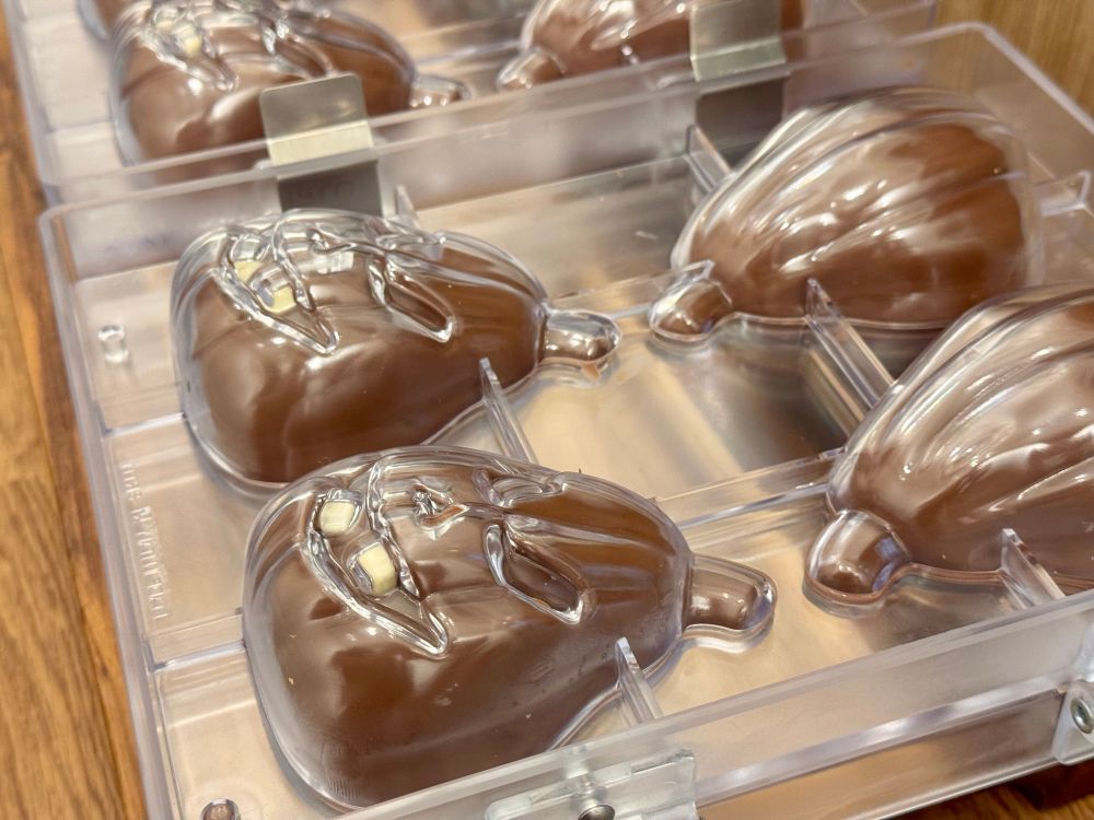Spooky chocolate pumpkins being moulded.