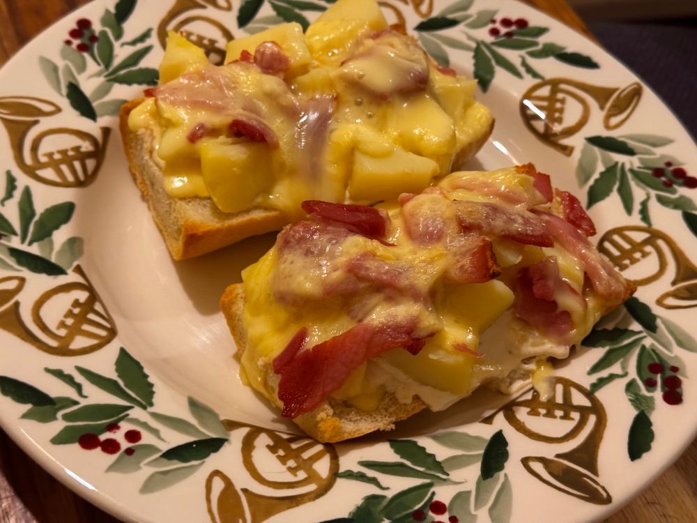 Some slices of baguette with cream, bacon, potatoes, and reblochon.