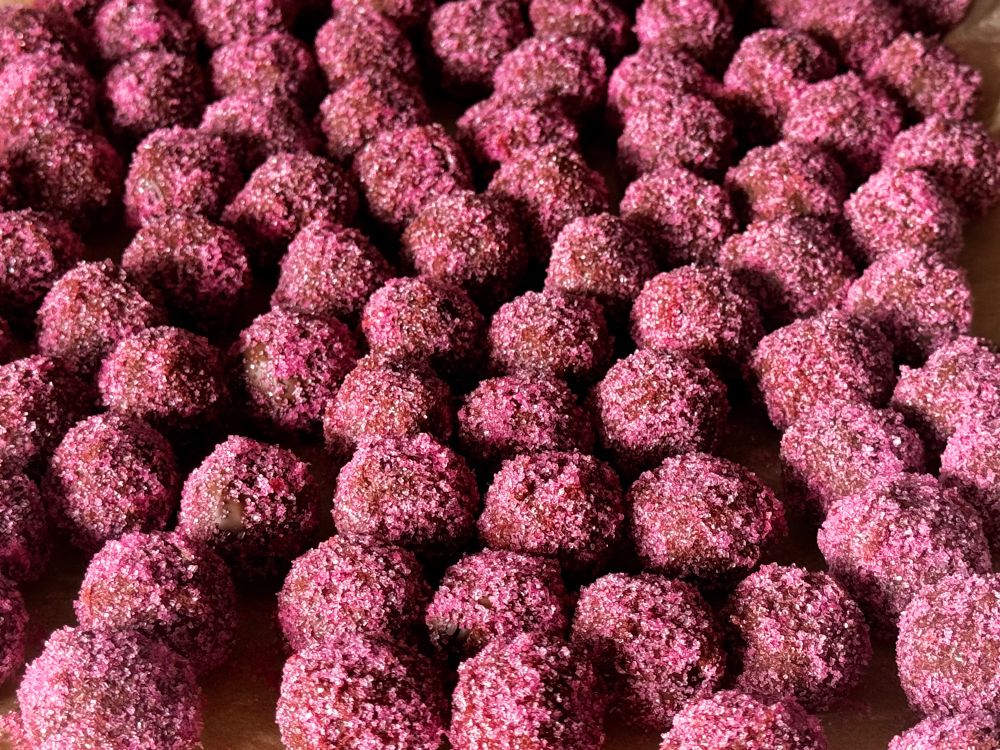 Rows of chocolate truffle coated with pink sherbet crystals