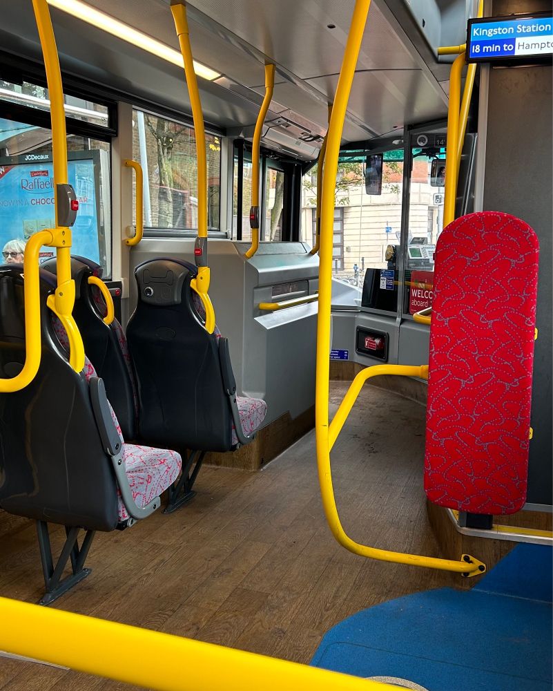 The inside of a bus. The floor is wooden panels.