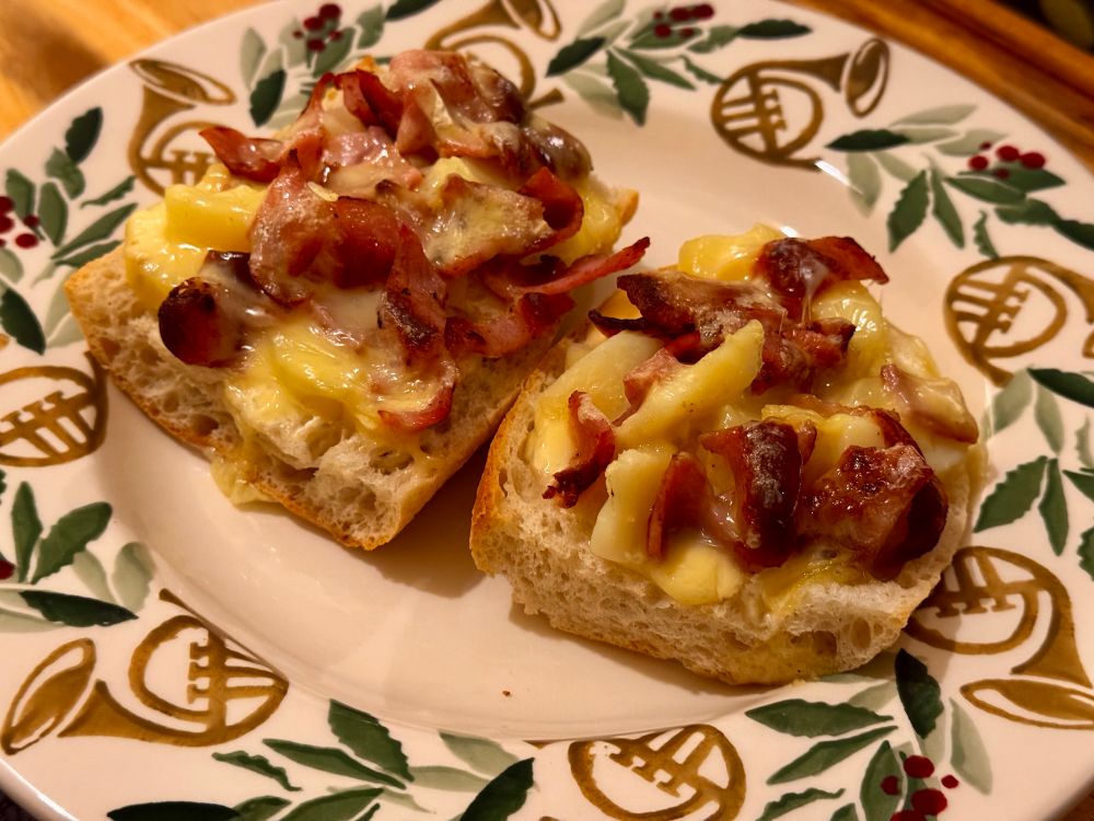 Two slice of bread with cream, potatoes, bacon, and reblochon. In a Christmas plate.