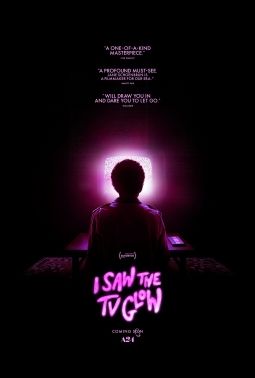 Post for A24's upcoming film called I saw the TV glow. It features the silhouette of a boy sitting on a couch staring at the glowing TV in front of him. A bright pink glow emanates from the TV, but the surrounding is pitch black.
