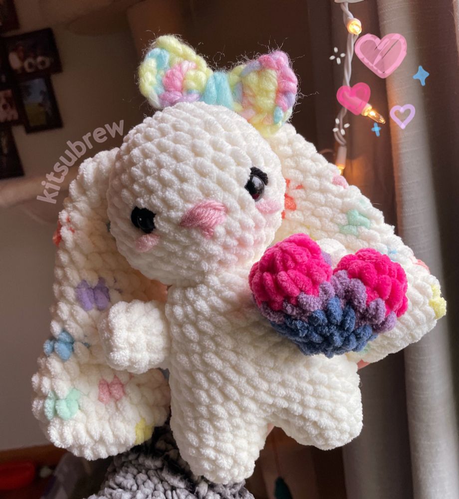 Crochet bunny holding a heart in the bi flag colors!