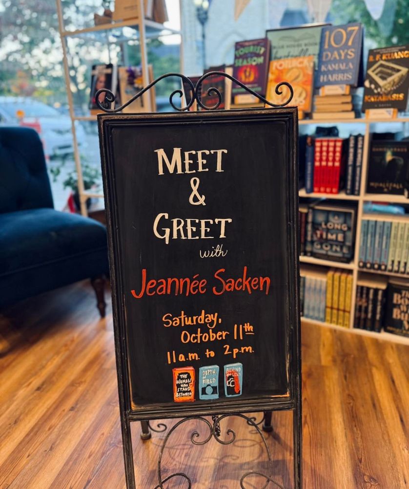 A photo of the black chalkboard inside the bookstore. It says- Meet & Greet with Jeannee Sacken. Saturday, October 11th. 11 a.m. to 2 p.m. 
---
Join us Saturday, October 11th anytime from 11 AM–2 PM at Blue House Books to celebrate the release of “The Women Who Stand Between”, the first in Jeannee Sacken’s brand-new series!

Known for her “Annie Hawkins” novels, Jeannee blends suspense, mystery, and women’s fiction in stories readers can’t put down. Plus, every book purchase includes a free copy of her new novella “Depth of Field”, the epilogue to the Annie Hawkins series!

Stop by anytime to chat with Jeannee and get your books signed!