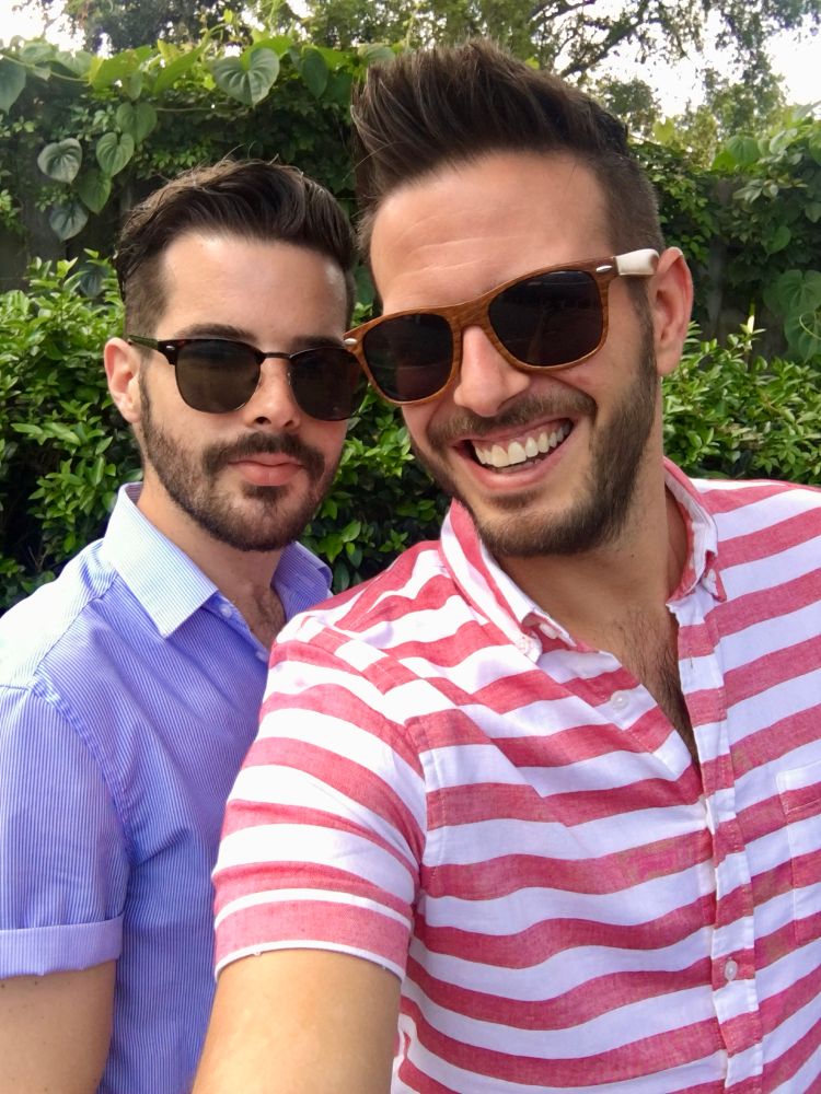 My boyfriend in a blue shirt and I am in a red and white striped shirt both wearing sunglasses.