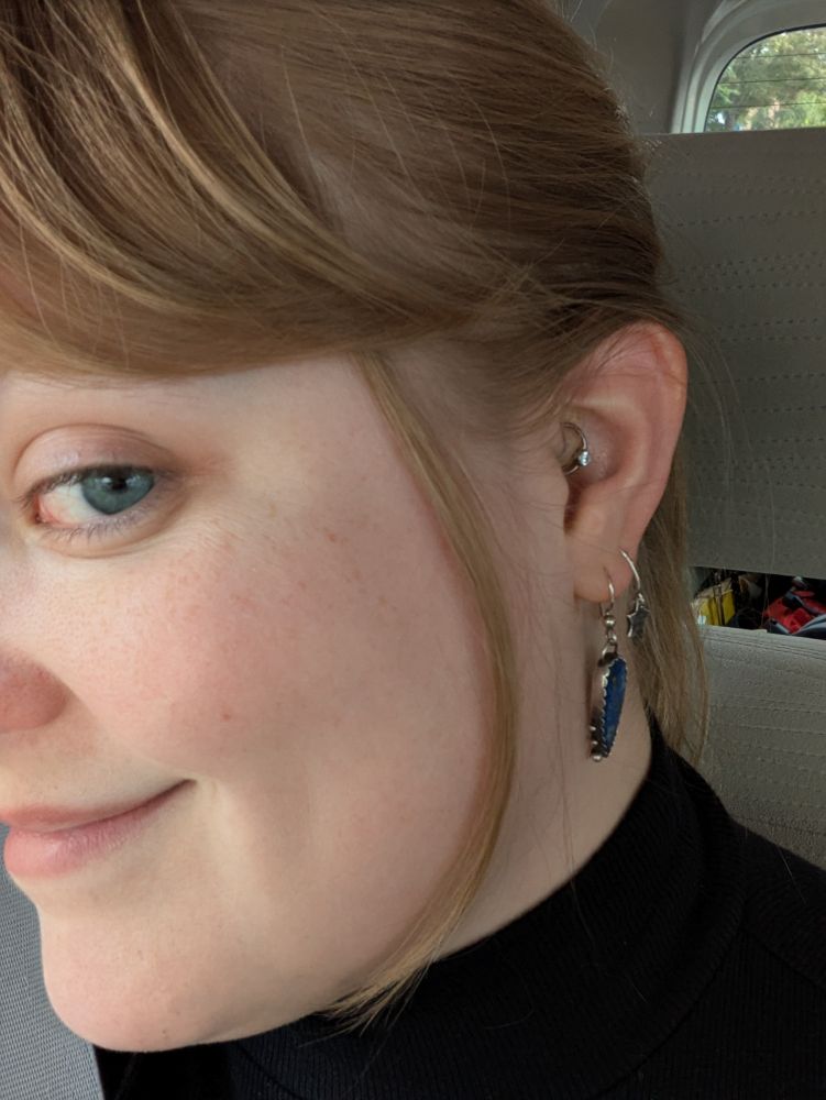 Side profile showing my ear and part of my face. There are two earlobe piercings and one daith piercing. 