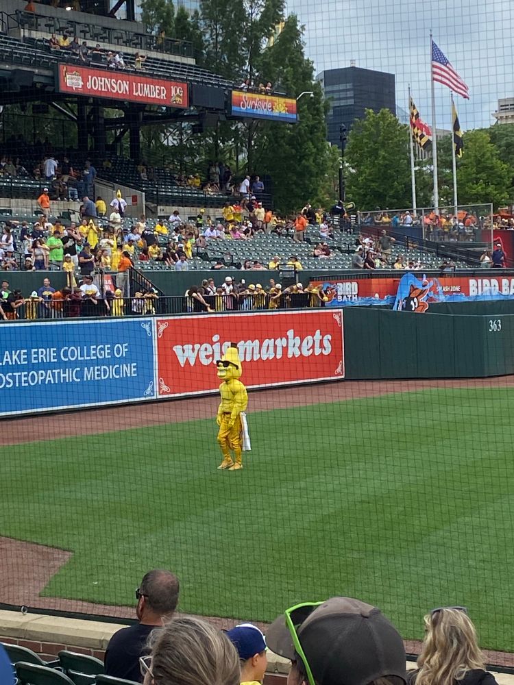 Humanoid banana in front of a weis markets sign. 