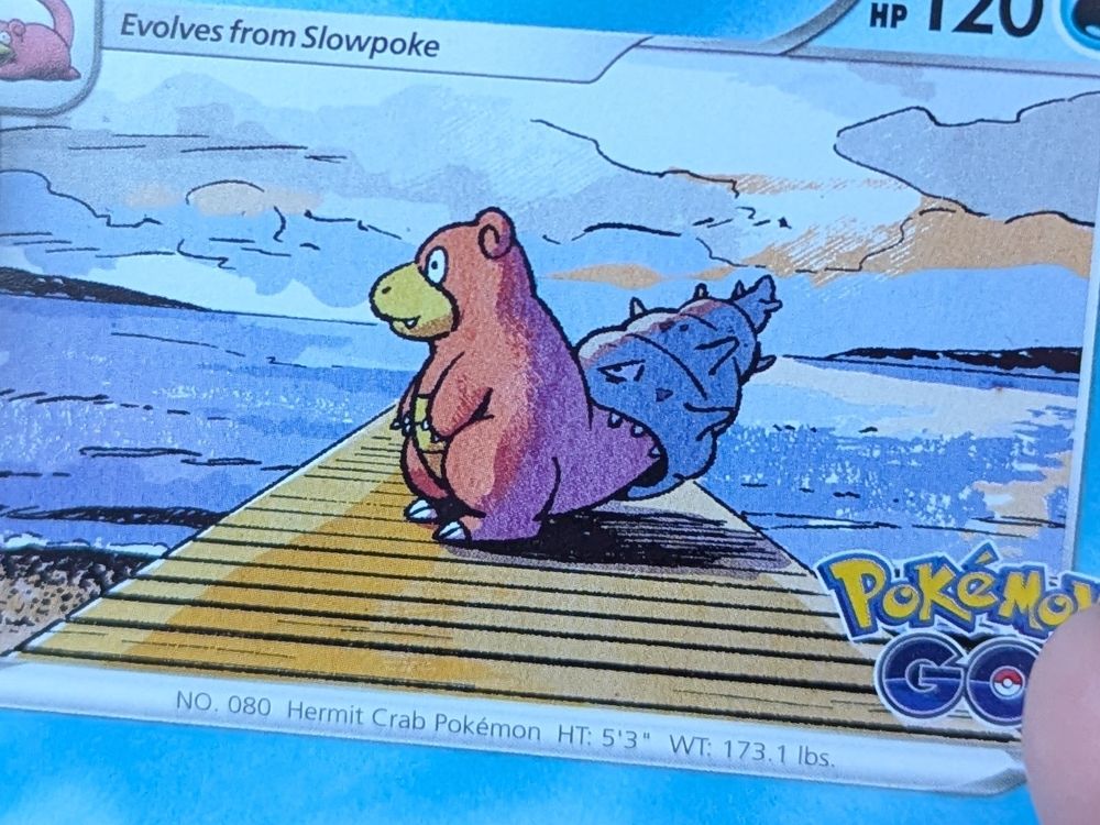 Close up of a Slowbro pokemon card where it is looking out at sunrise on a dock