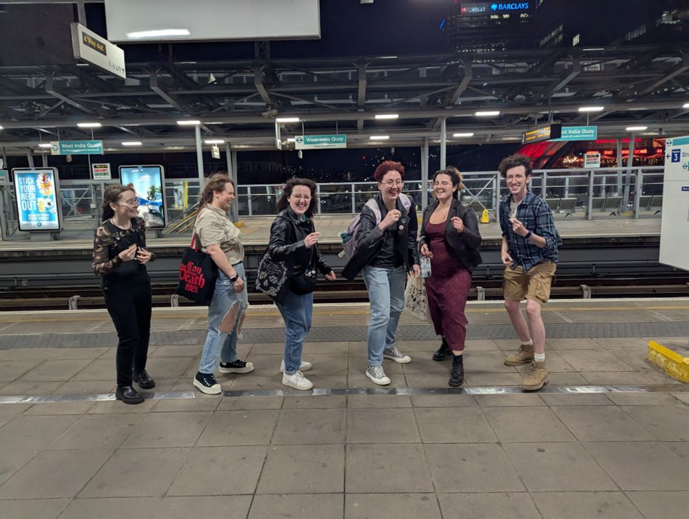 6 gay people fingersnapping on a DLR platform