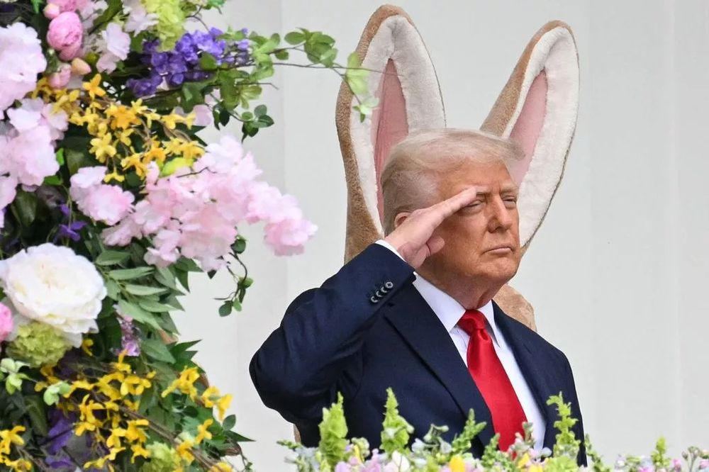 donald trump saluting, with bunny ears sticking up behind his head so that he looks utterly ridiculous (even more so than usual)