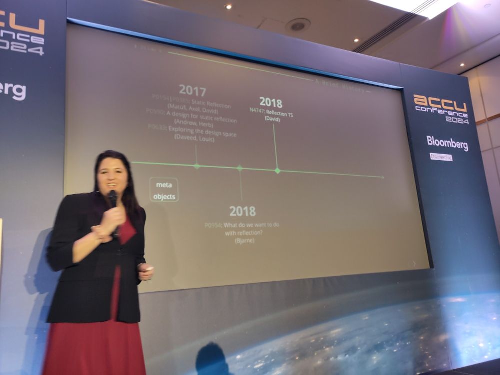 Inbal Levi in front of her slide with the timeline of the evolution of C++ reflection