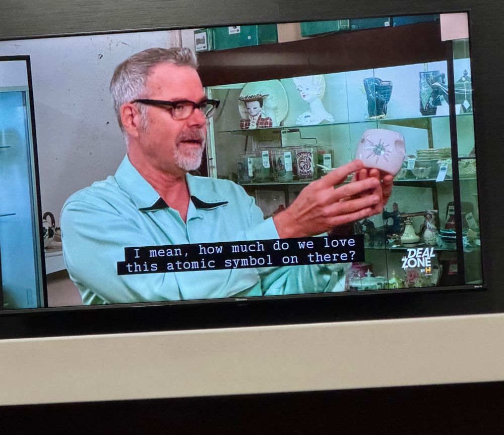 Antique dealer holding up an atomic dish that’s part of a set valued at $1000