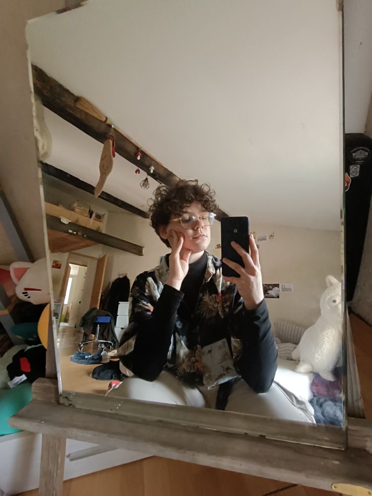 Photo de moi accroupi devant le miroir, un miroir en argent (ou mercure) de taille moyenne, posé sur un vieux chevalet en bois gris