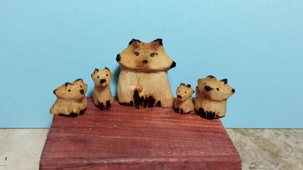 5 petits renards en bois. Les pattes, yeux, oreilles et museaux sont noircis