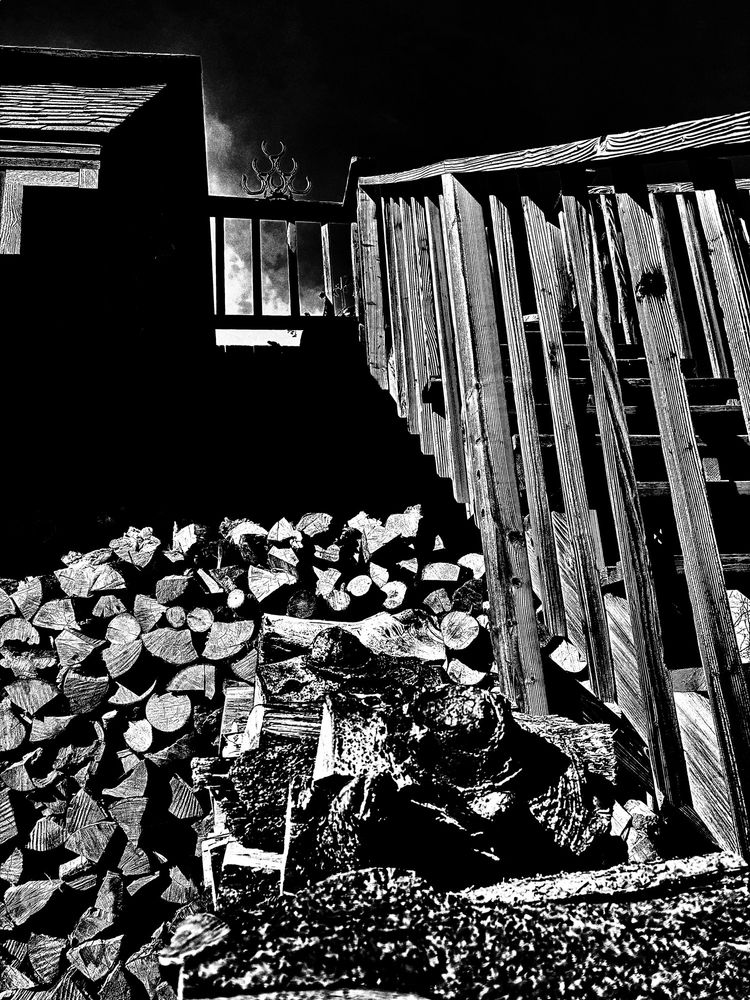 B&W photo of the wood pile collected against the house.. (3 more cords to go)
