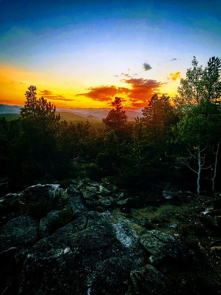 Sunset from my backyard this week. Rock cropping and trees with vibrant hues as the day closes for the night.
