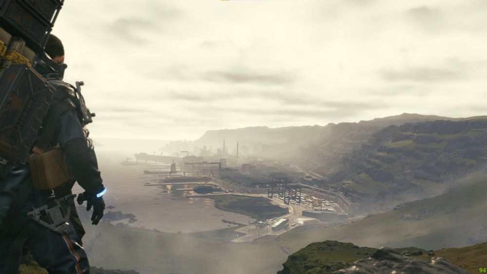 Sam porter looking out over a misty port city with a small ridge trailing into the distance beyond it