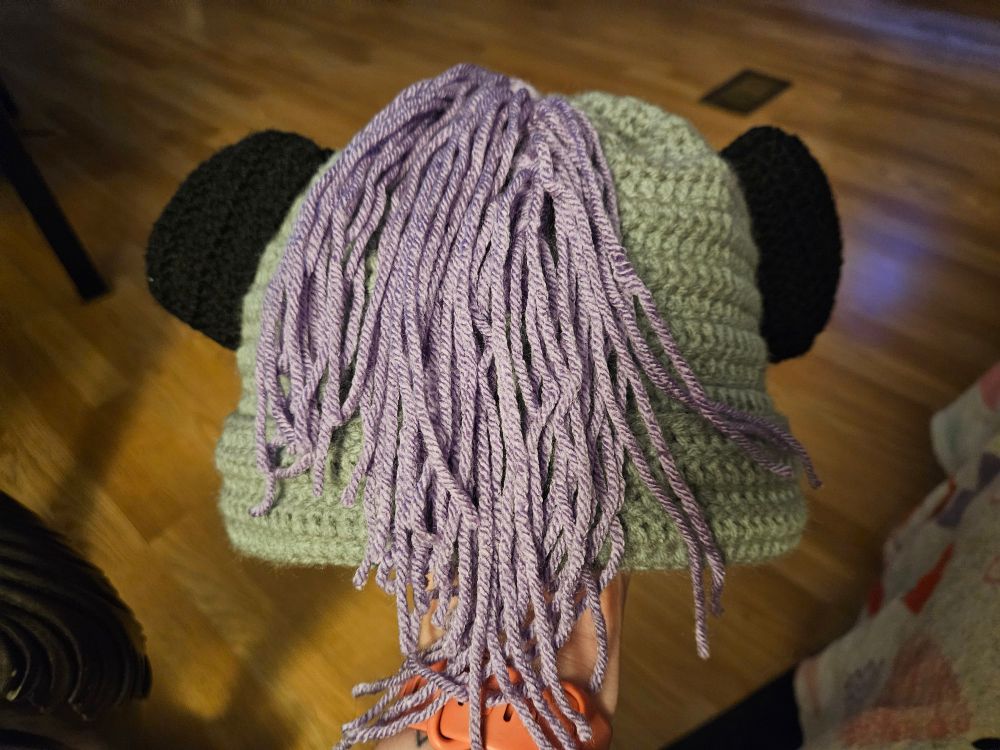 Back of grey and white beanie with magnetic lavender hair.