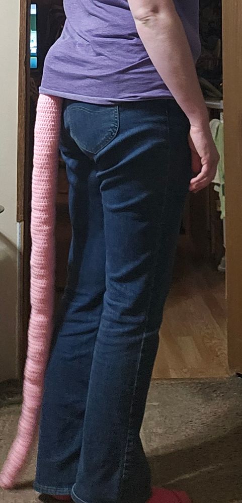 Woman wearing a crochet opossum tail.