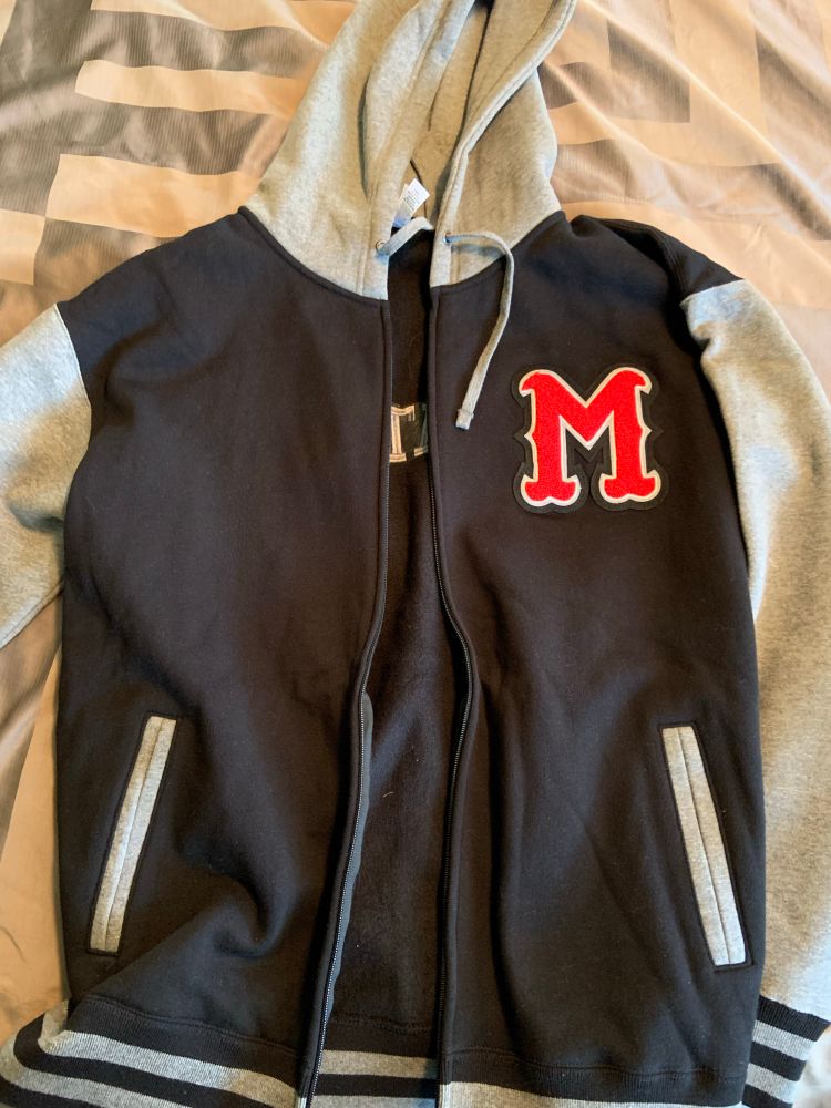 A black and grey hoodie with a single red letter “M” over the heart.