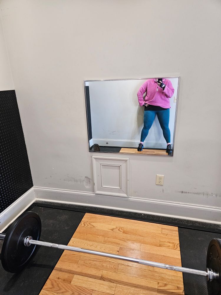 Photo with barbell weights and a mirror reflection of the poster