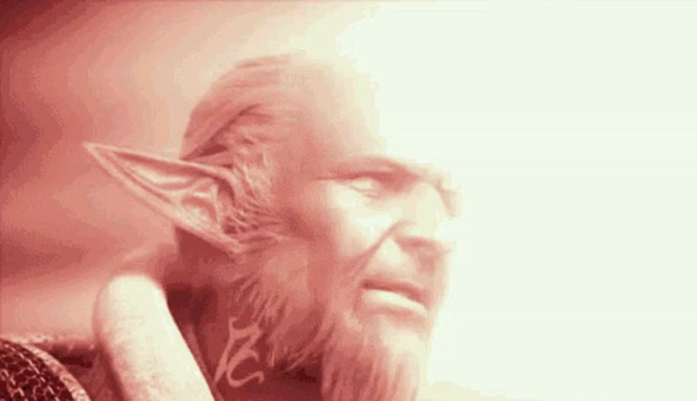 a man with a beard and elf ears has a red light behind him