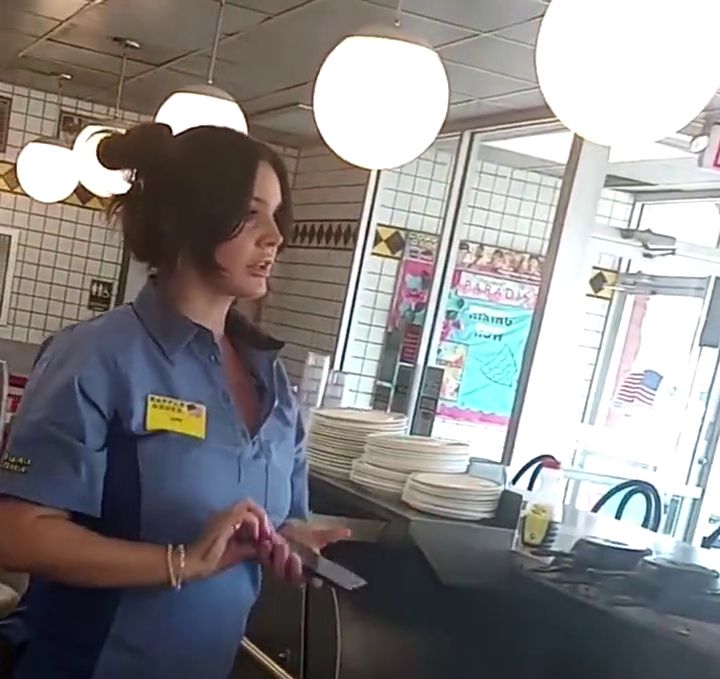 lana del rey working at a waffle house with a dumfounded expression