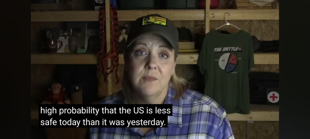 Femme with baseball cap looks at camera. Closed captions read "high probability that the US is less safe today than it was yesterday"
