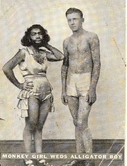 Percilla and Emmitt after marrying. They are standing together in performer costumes. Label reads “Monkey Girl weds alligator boy”
