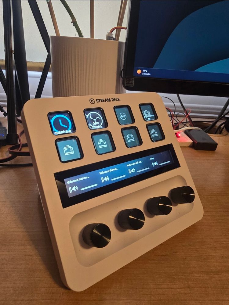 Stream Deck + en un escritorio con varios monitores y una maceta inteligente de fondo