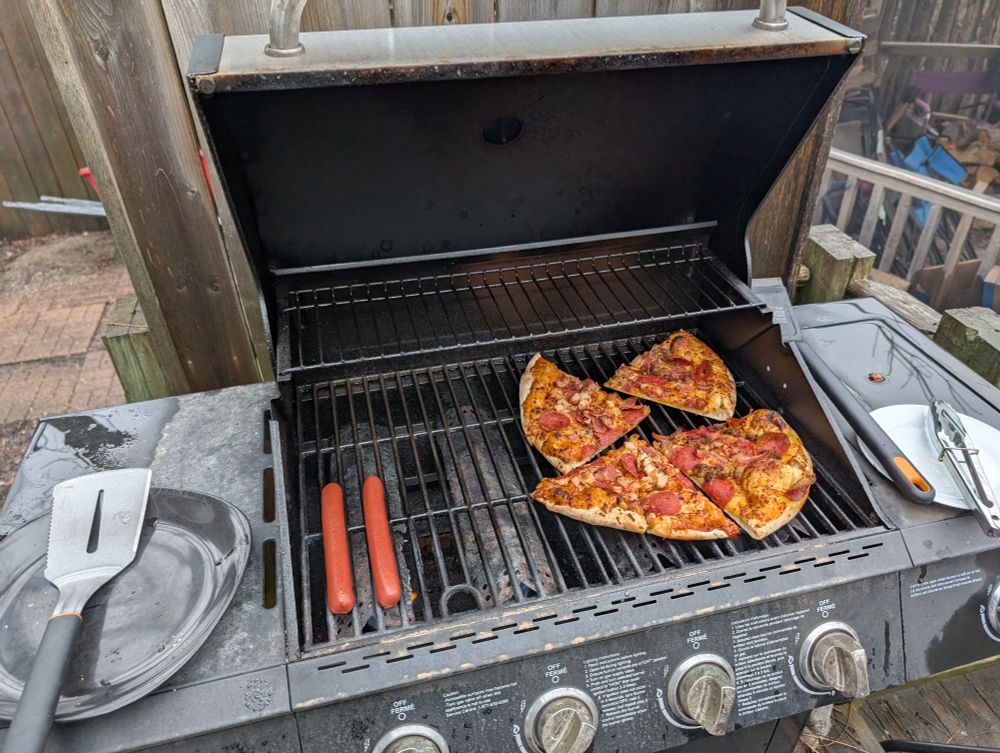 Pizza and hot dogs on BBQ grill