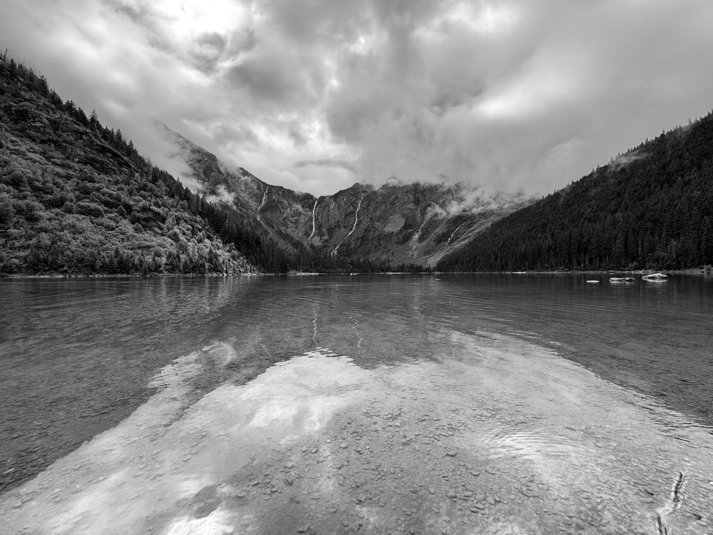 A ridge and three waterfalls reflected off of Avalanche Lake