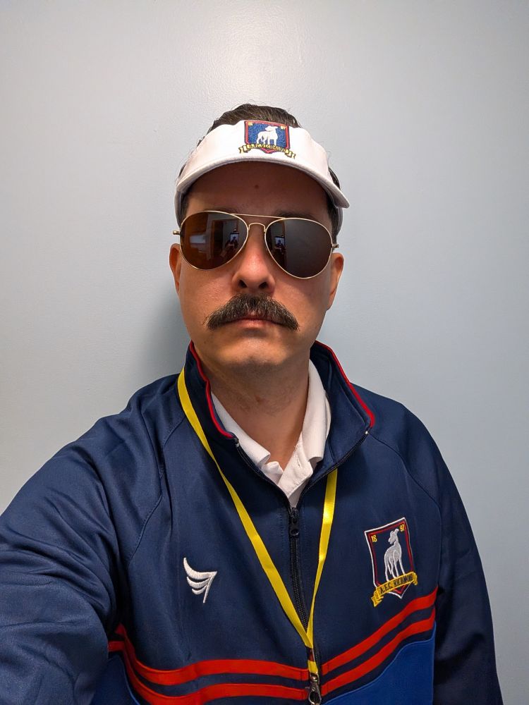 Selfie of myself dressed as Ted Lasso, wearing brown aviator sunglasses, a blue AFC Richmond track jacket with white polo shirt collar poking out underneath, whistle with yellow lanyard, and a white AFC Richmond visor. 

Not to mention a formidable mustache  and chin that hasn't seen sunlight in roughly 9 years.