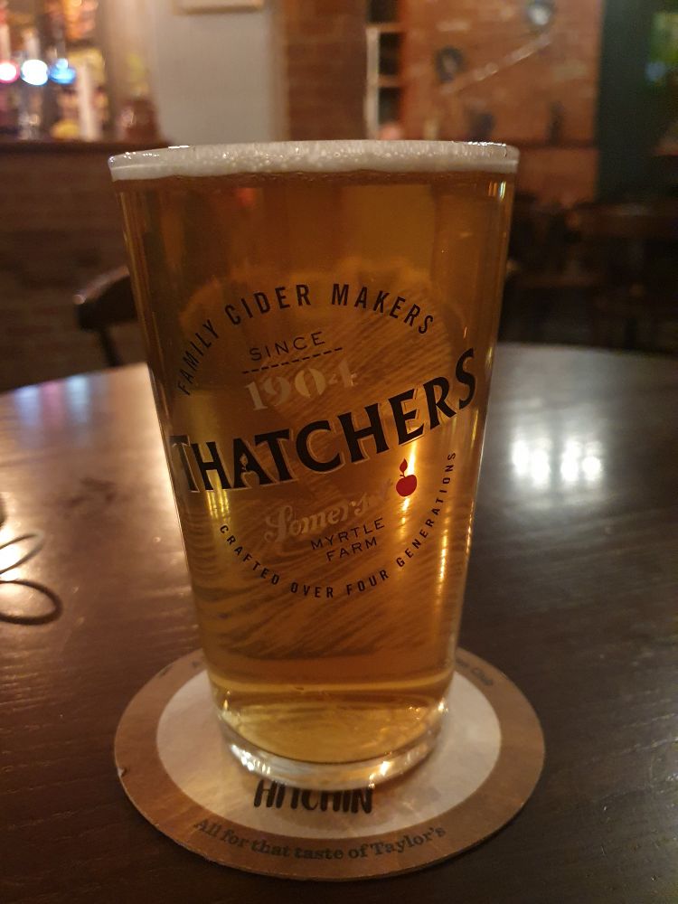 A pint of Thornbridge Jaipur beer, in a straight pint glass branded for Thatchers cider.