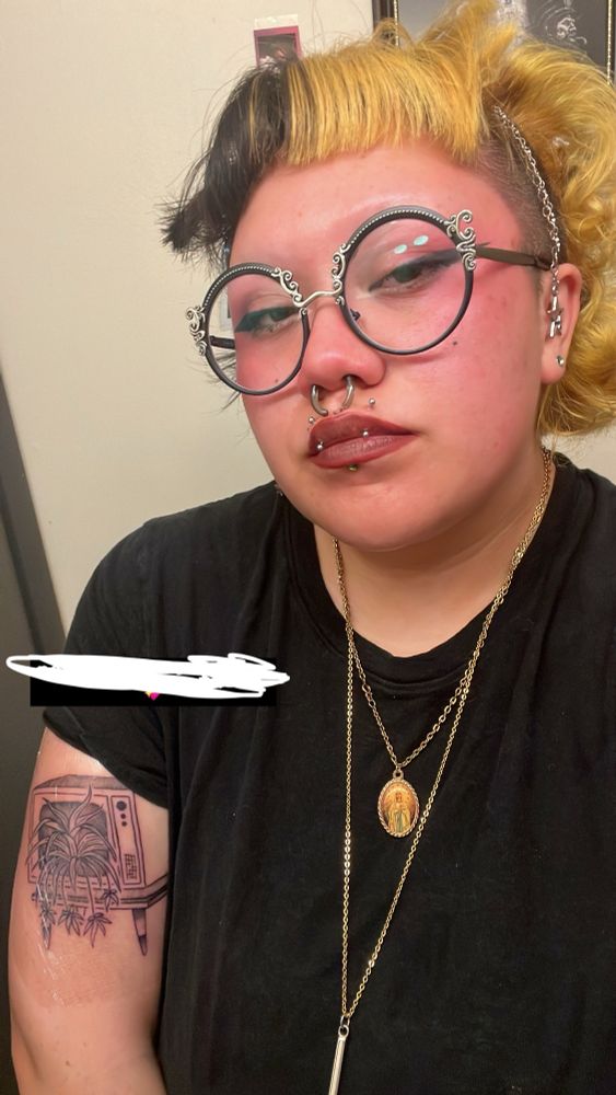 Me wearing 2 gold necklaces and looking into the camera either my circle lenses. my arm is freshly tattooed !
tattoo is a tv with spiderplants coming out of it
