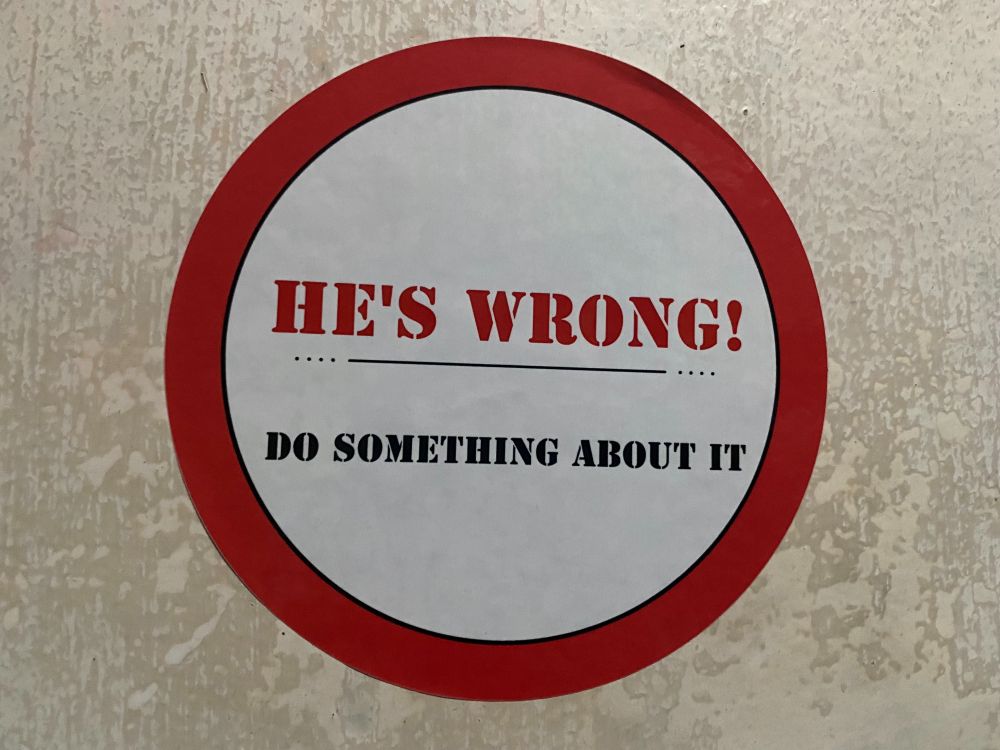 Sticker found on bathroom wall in an undisclosed location in Southern California.  It reads: "HE'S WRONG! DO SOMETHING ABOUT IT" 