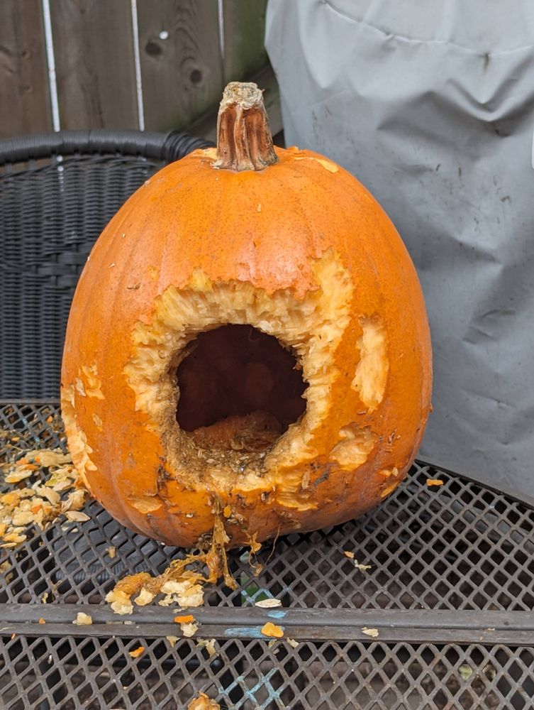 A pumpkin with a hole burrowed into the side