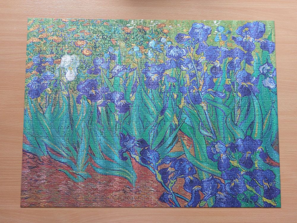 A finished puzzle of Vincent Van Gogh's painting "Irises". Slight light reflexions in stripes across the puzzle indicate the mentioned shimmer.