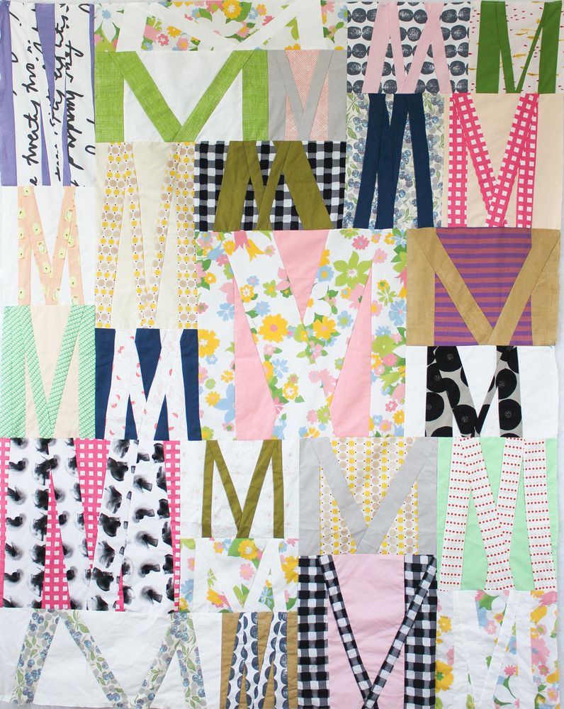 Improv Baby quilt with the letter M all over