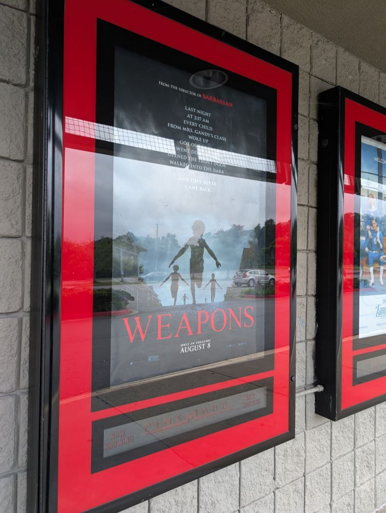 Glare on the case of the movie poster for weapons. 