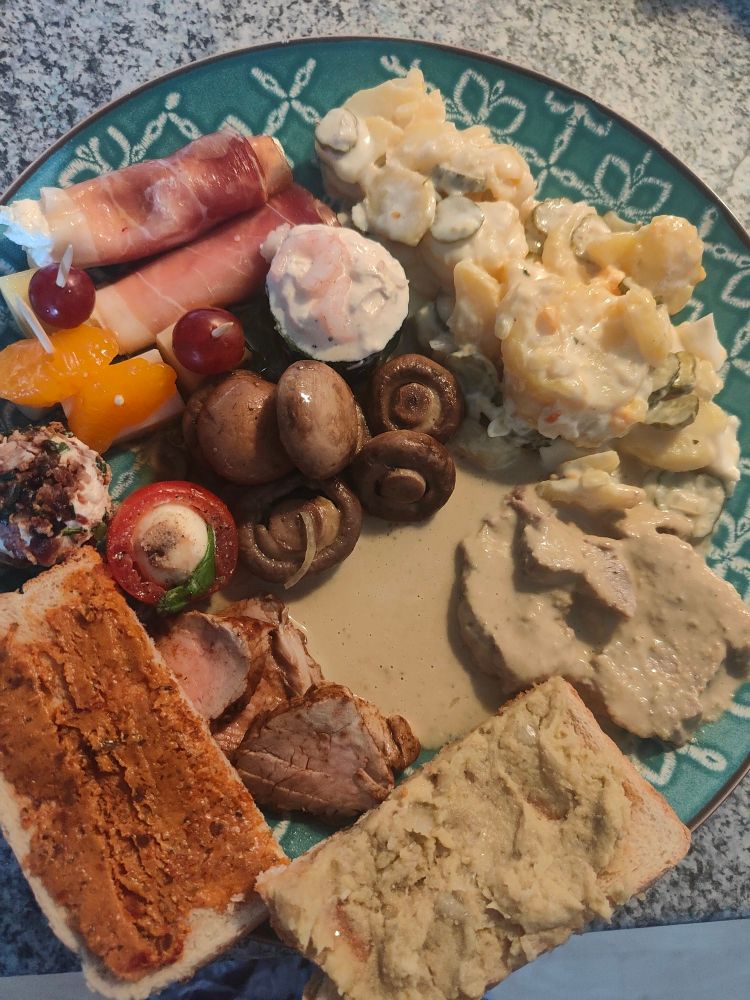 Großer Teller mit Vitello Tonnato, Kartoffelsalat, Parmaschinken-Röllchen, Käsepickern, mit Lachscreme gefüllter Gurke, eingelegten Champignons, Balsamico-Filet, gefüllter Tomate, Frischkäseballchen mit Bacon-Mantel, Toast mit Auberginen-Aufstrich und Tomatenbutter