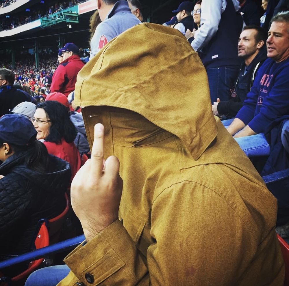 An unidentified person giving the middle finger at what looks like a sporting event at Fenway Park