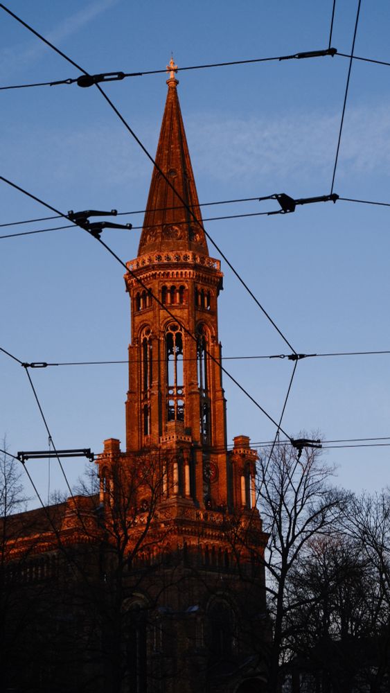 The evening sun shines on the Zionchurch an Zionkirchplatz in Berlin, Mitte on a Sunday in January 2025. 
