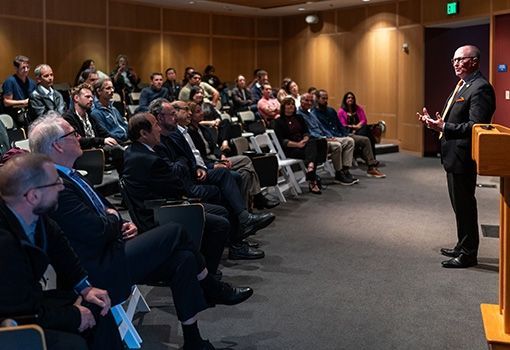 person speaking to a group of people in an auditorium