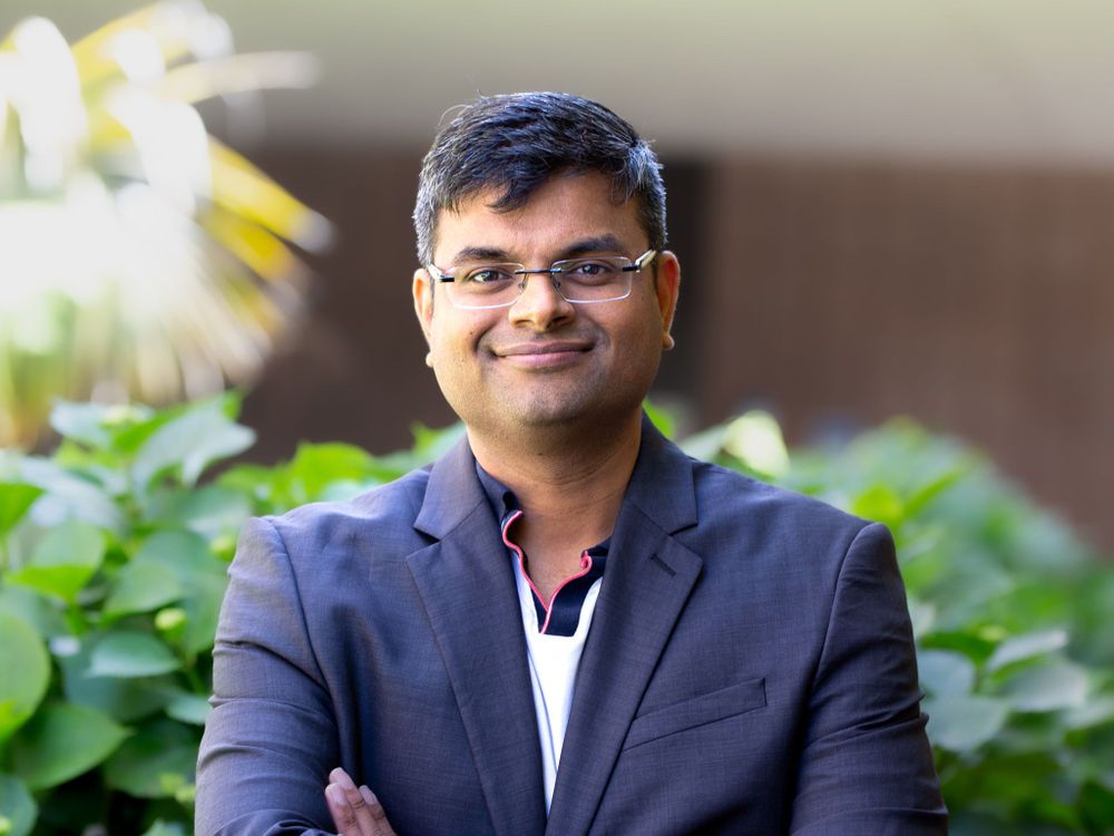 Arpit Gupta standing in front of greenery