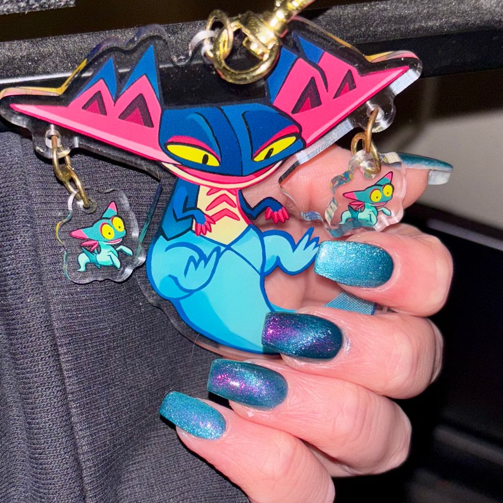 Dragon Darts Nail Polish by Arcana Lacquer, posing with a dragonpult acrylic charm taken with phone flash