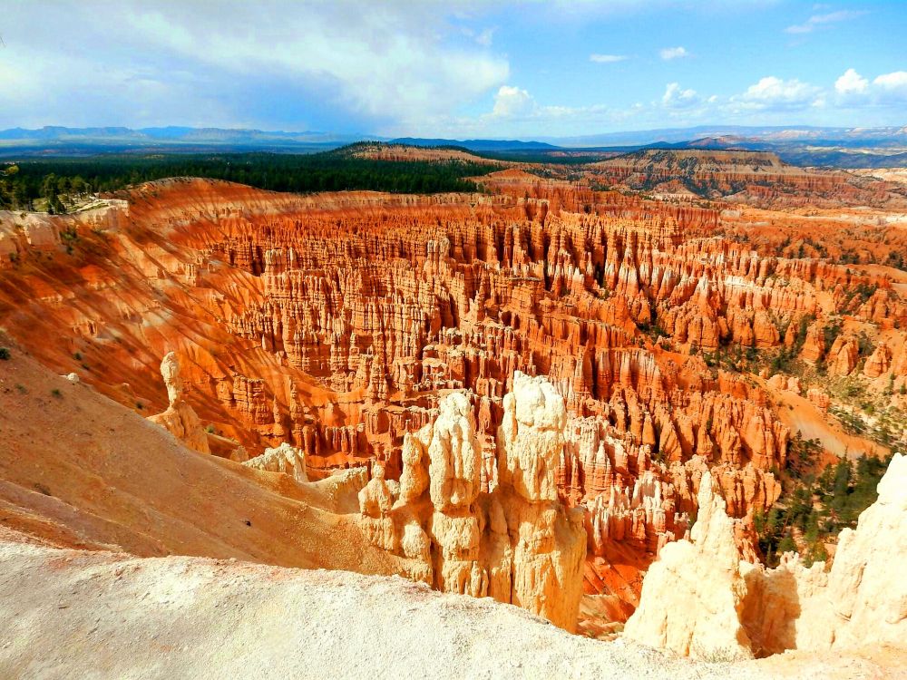 The sun dips low, casting long shadows across the hoodoos of Bryce Canyon. From Inspiration Point, the amphitheater unfolds like a breathtaking stage set. Thousands of crimson spires, sculpted by wind and water over eons, rise in a surreal tapestry against the vibrant sky. The air is crisp and thin, carrying the whispers of ancient stories etched into the canyon walls. A sense of awe washes over you as you contemplate the vastness of time and the delicate beauty of this natural wonder.
